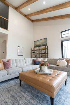 Down to Earth Projects | Kaysville Residence - leather ottoman on blue rug with sectional 