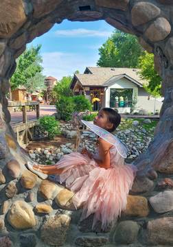 Woodland Fairy Festival - girl sitting in rock window dressed as a fairy 