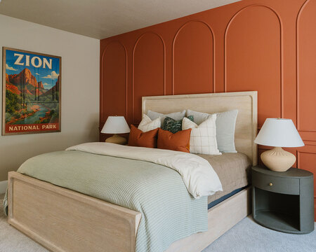 Down to Earth Projects | Utah Valley Parade at The Legacy at Meadow Ridge - guest room with orange wall and light bed with nightstand 